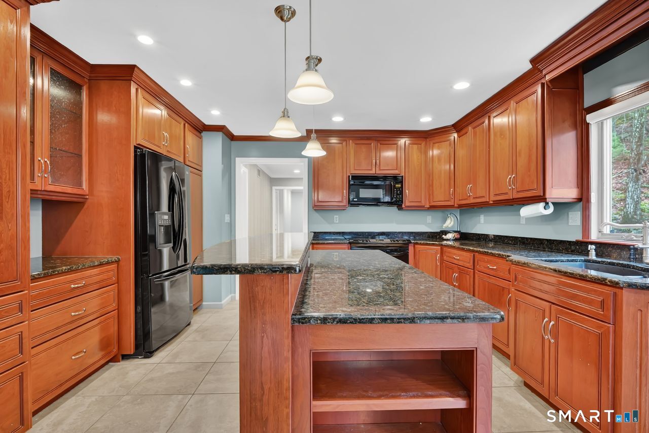 104 Old Farms Road Glastonbury, CT 06073 - Photo 7 of 40 a kitchen with stainless steel appliances granite countertop wooden cabinets a refrigerator and a sink