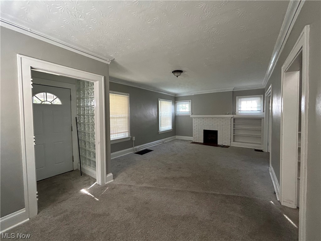 13604 Claiborne Road Cleveland, OH 44112 - Photo 3 of 18 Living room with crown molding, dark carpet, and a textured ceiling