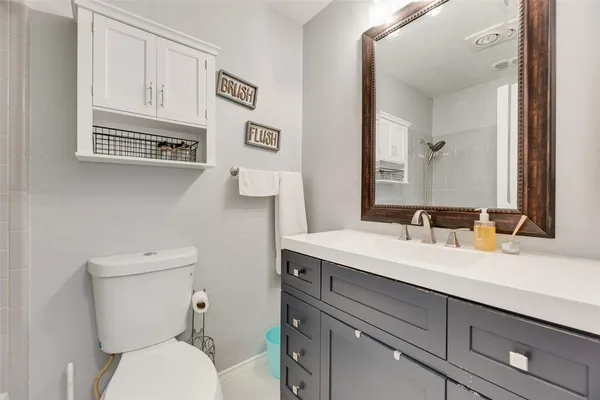 a bathroom with a toilet a sink and mirror