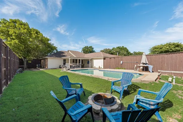 a view of house with backyard and outdoor seating