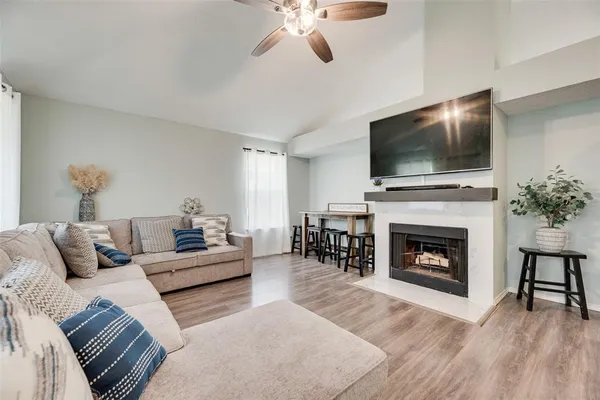 a living room with furniture a flat screen tv and a fireplace