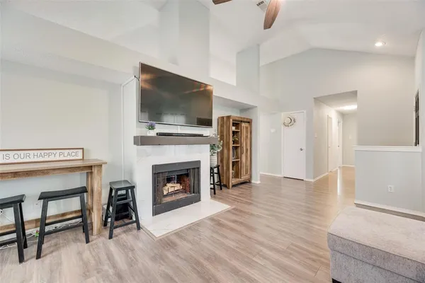 a living room with furniture a flat screen tv and a fireplace