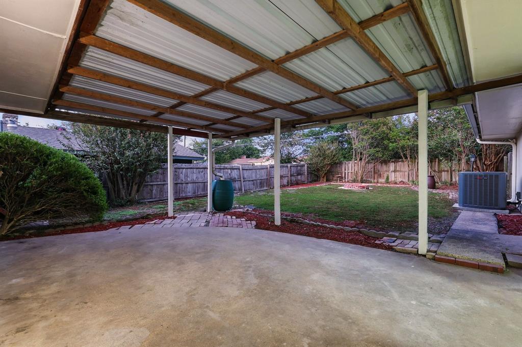 3734 Kimball Ridge Drive Dallas, TX 75233 - Photo 10 of 13 a view of a backyard with table and chairs under an umbrella with a small yard