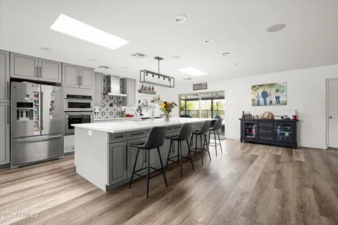 a kitchen with stainless steel appliances a dining table chairs microwave and sink