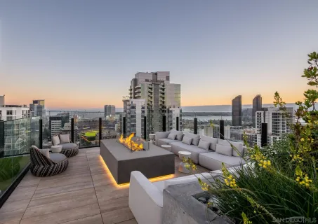 a view of a roof deck with couches and potted plants