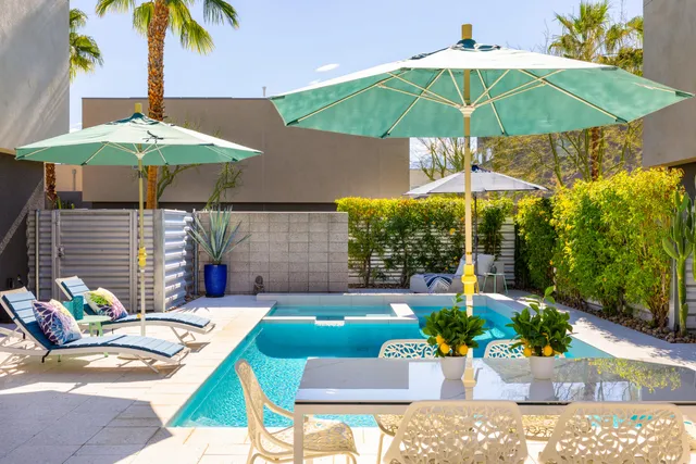 a view of an outdoor sitting area with chairs and umbrella