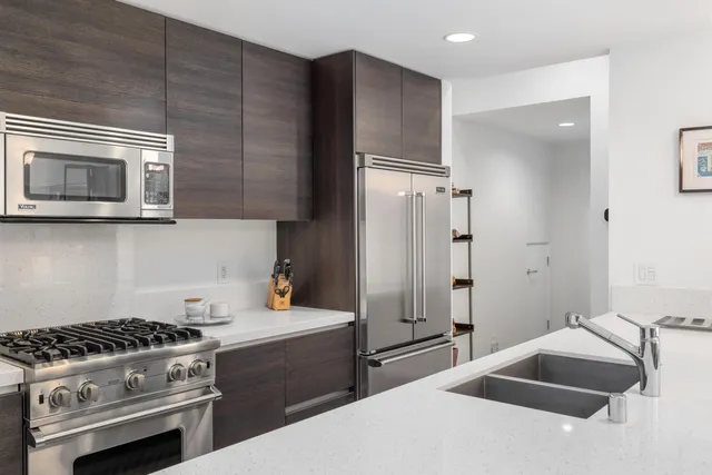 a kitchen with stainless steel appliances granite countertop a stove a refrigerator and a microwave