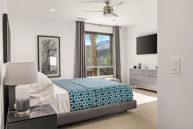 a bedroom with a bed and a flat screen tv