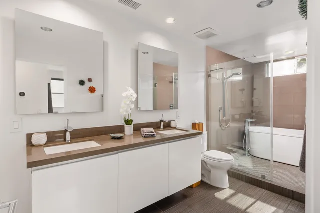 a bathroom with a double vanity sink a toilet and a mirror