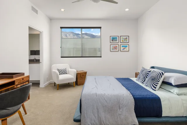 a bedroom with bed couch and window