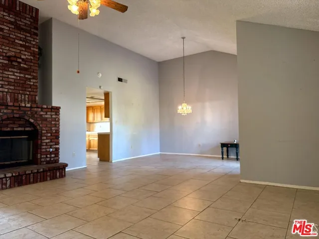 a view of empty room with a fireplace and window