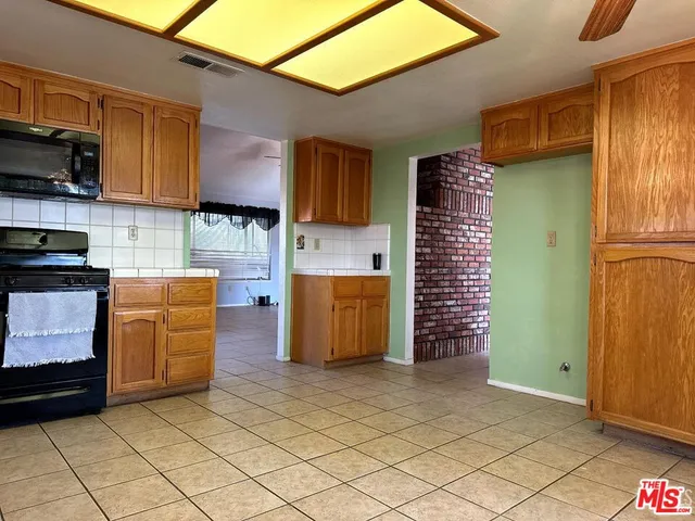 a kitchen with a refrigerator a stove top oven and cabinets