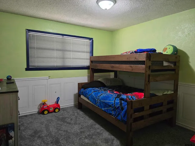 a bedroom with a bed and a tv on the dresser
