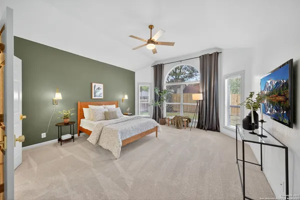 a spacious bedroom with a bed and ceiling fan