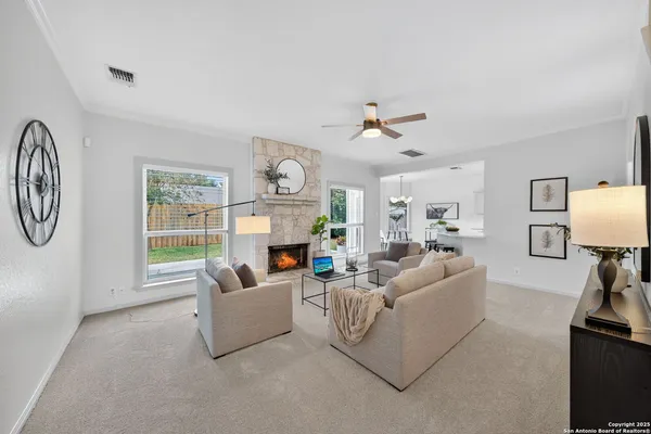 a living room with furniture a fireplace and a window