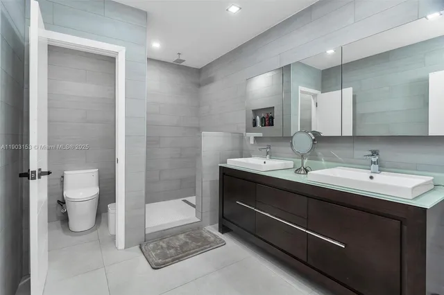 a bathroom with a sink a toilet and a large mirror