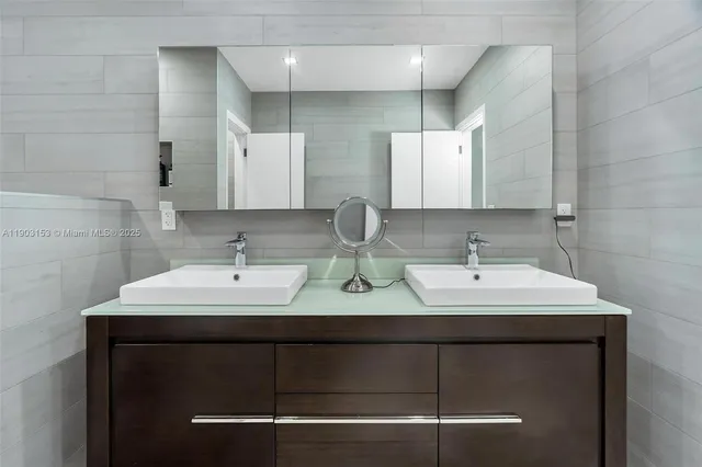 a bathroom with double sink and a mirror