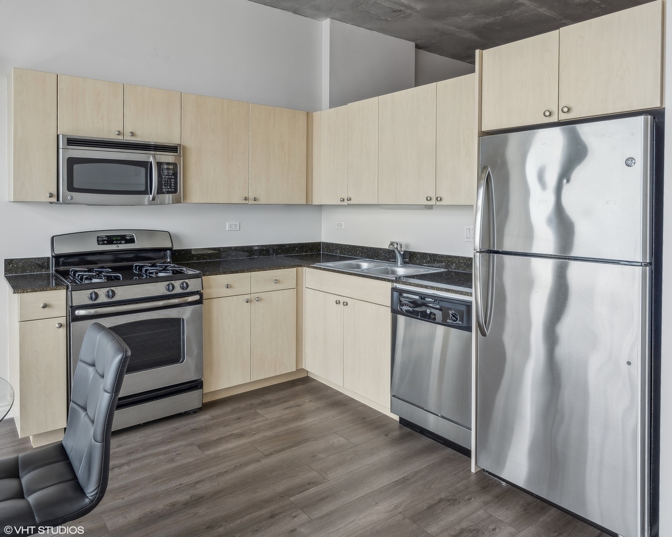 235 West Van Buren Street, Unit 2708 Chicago, IL 60607 - Photo 4 of 10 a kitchen with cabinets stainless steel appliances and wooden floor