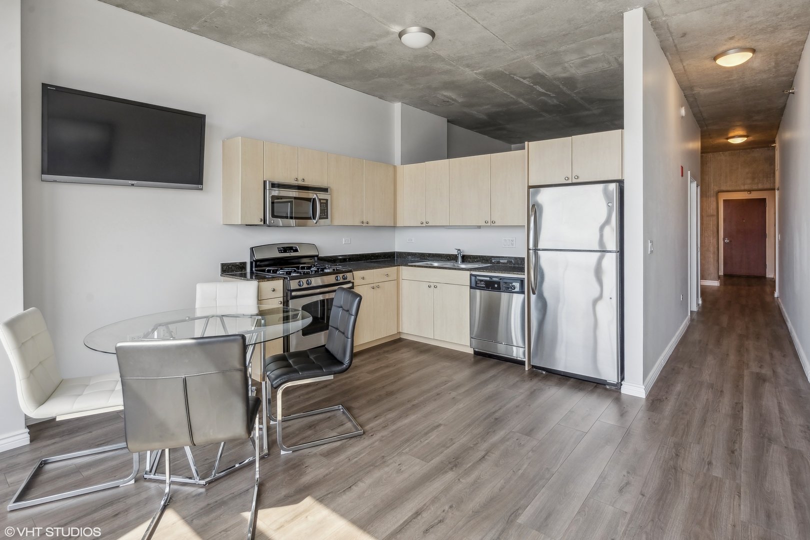 235 West Van Buren Street, Unit 2708 Chicago, IL 60607 - Photo 5 of 10 a kitchen with stainless steel appliances a refrigerator a stove a microwave and furniture