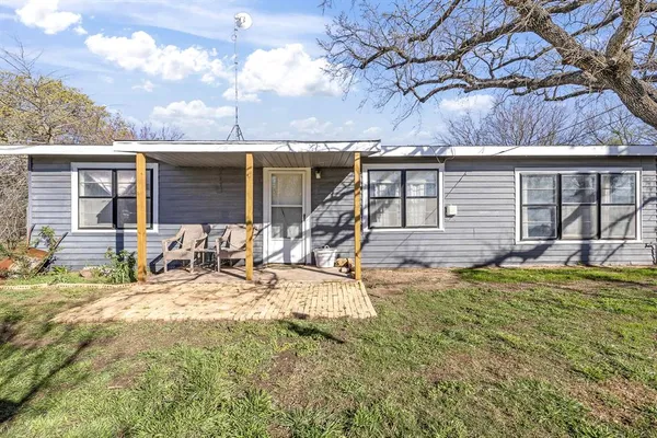 a view of a house with backyard and sitting area