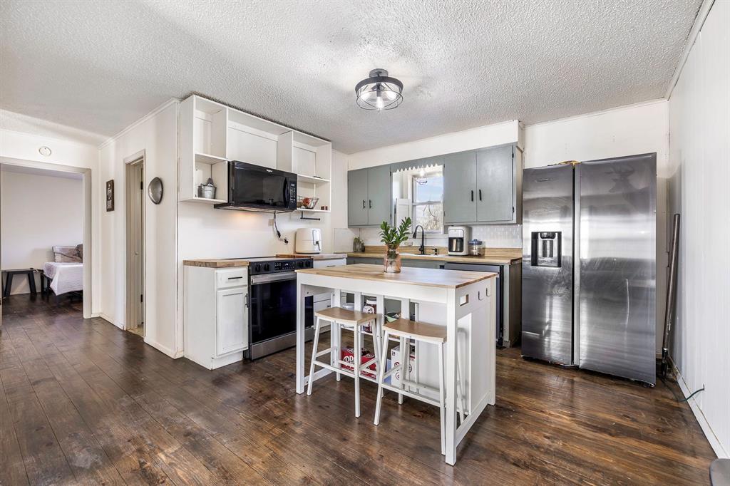 132 Maple Dublin, TX 76446 - Photo 5 of 27 a kitchen with kitchen island a sink stove and refrigerator