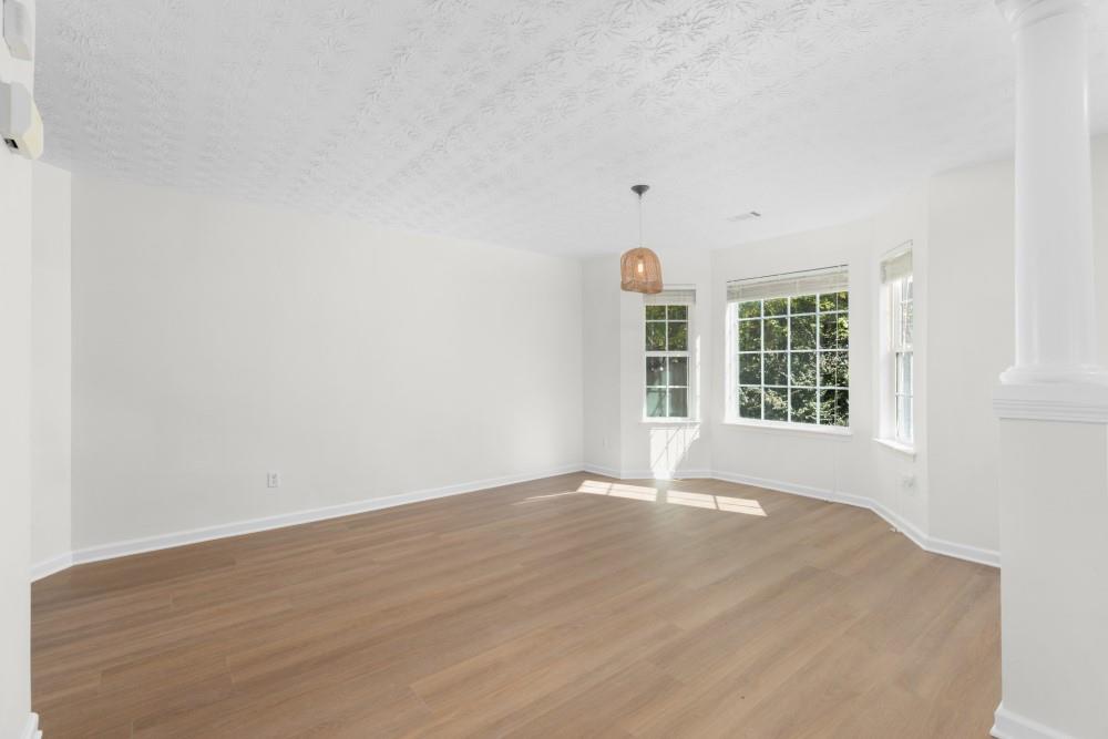 3501 Bogan Mill Road Northeast Buford, GA 30519 - Photo 11 of 59 an empty room with wooden floor and windows