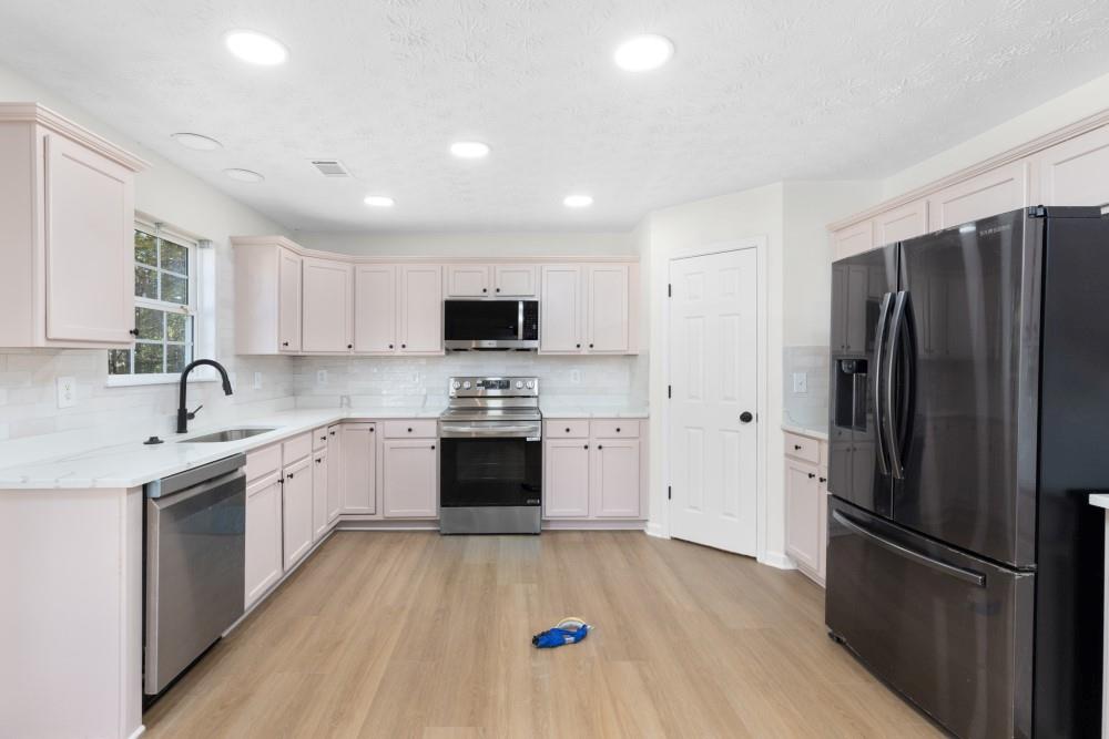 3501 Bogan Mill Road Northeast Buford, GA 30519 - Photo 19 of 59 a kitchen with stainless steel appliances a refrigerator sink and cabinets