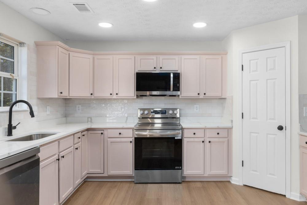 3501 Bogan Mill Road Northeast Buford, GA 30519 - Photo 23 of 59 a kitchen with granite countertop white cabinets and stainless steel appliances