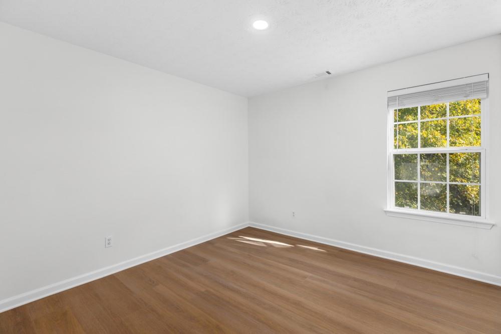 3501 Bogan Mill Road Northeast Buford, GA 30519 - Photo 36 of 59 an empty room with wooden floor and windows