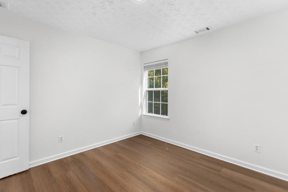3501 Bogan Mill Road Northeast Buford, GA 30519 - Photo 39 of 59 an empty room with wooden floor and windows