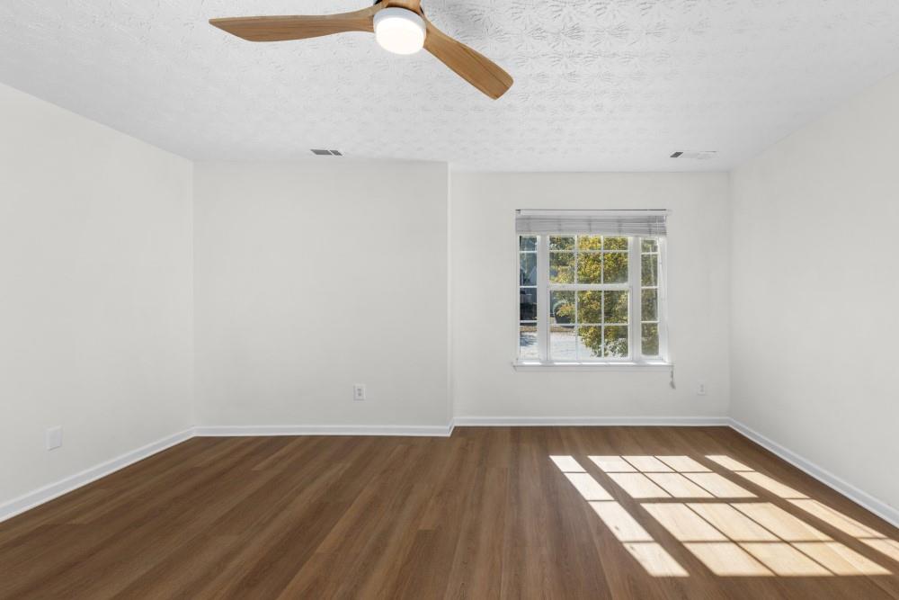 3501 Bogan Mill Road Northeast Buford, GA 30519 - Photo 46 of 59 an empty room with wooden floor and windows