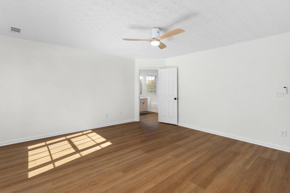 3501 Bogan Mill Road Northeast Buford, GA 30519 - Photo 47 of 59 an empty room with wooden floor and windows