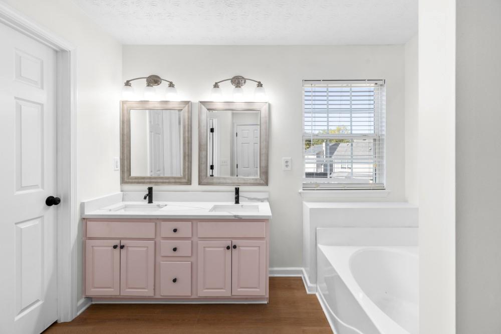 3501 Bogan Mill Road Northeast Buford, GA 30519 - Photo 51 of 59 a spacious bathroom with double vanity a mirror a bathtub and window