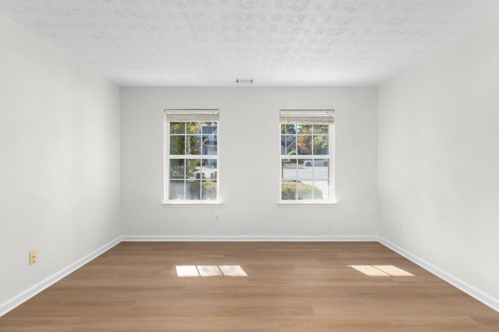 3501 Bogan Mill Road Northeast Buford, GA 30519 - Photo 8 of 59 an empty room with wooden floor and windows