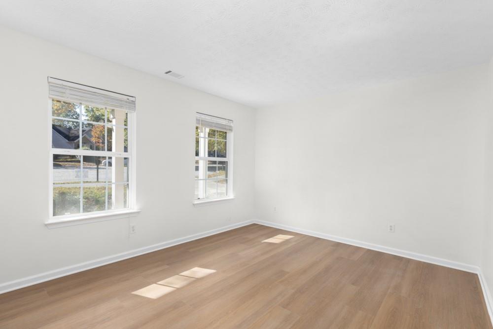 3501 Bogan Mill Road Northeast Buford, GA 30519 - Photo 9 of 59 an empty room with wooden floor and windows