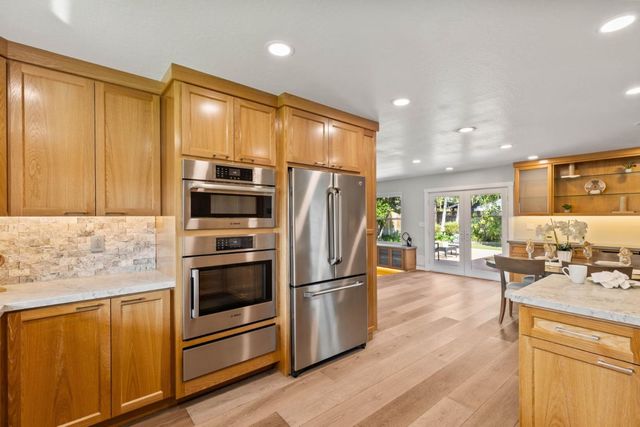 a kitchen with stainless steel appliances granite countertop a refrigerator stove and sink