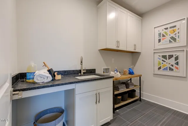 a kitchen with stainless steel appliances kitchen island granite countertop a dining table chairs stove and white cabinets