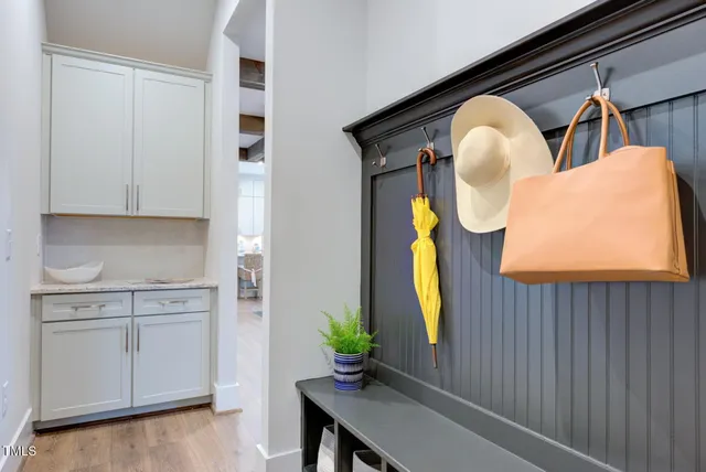 a hallway with painting on the wall and a potted plant