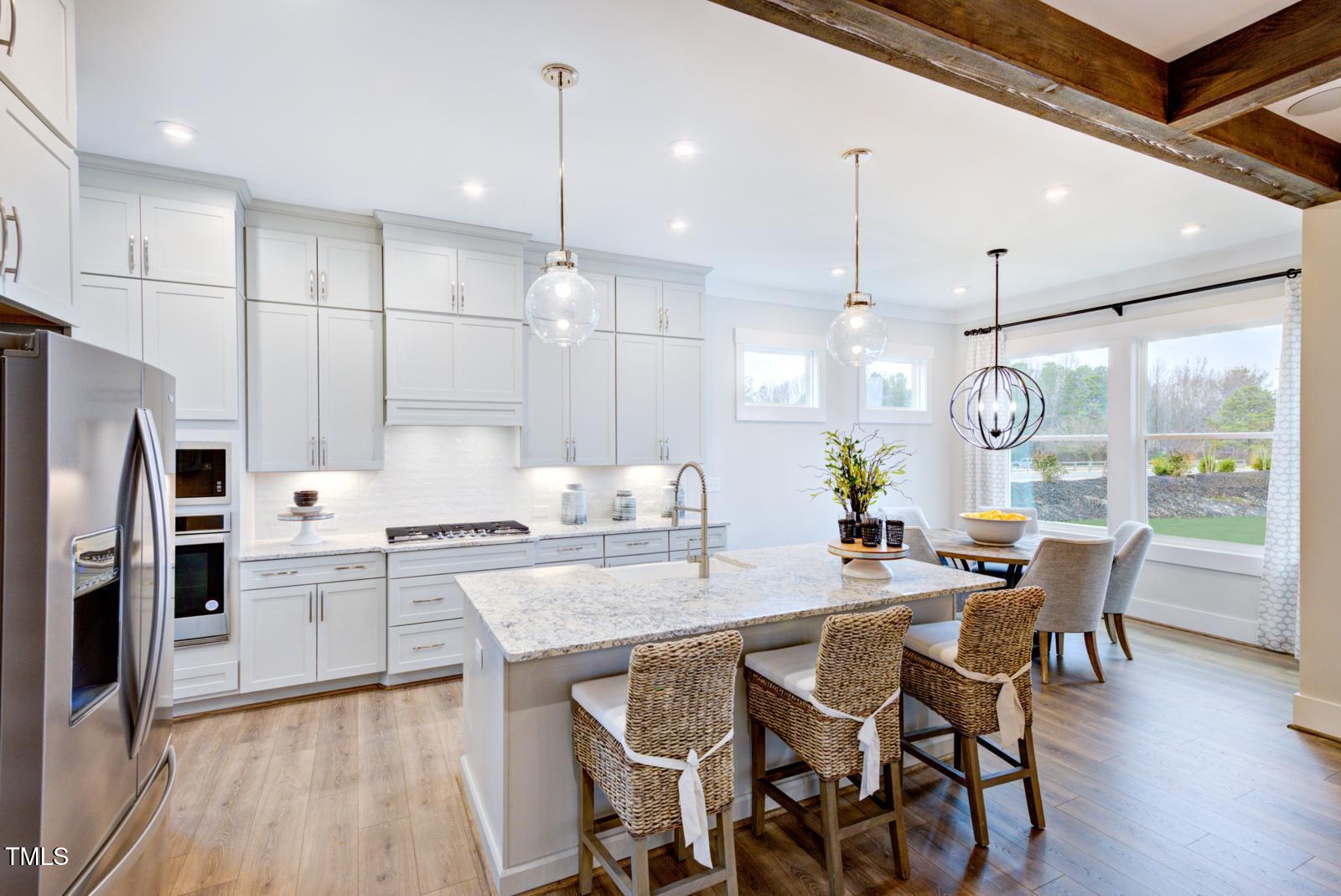 149 Brandy Mill Pittsboro, NC 27312 - Photo 45 of 69 a kitchen with stainless steel appliances kitchen island granite countertop a dining table chairs stove and white cabinets
