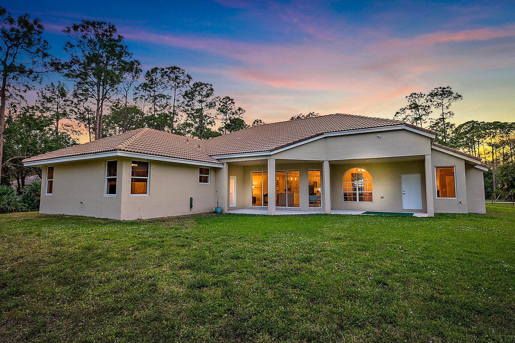 15644 Billy Goat Lane Jupiter, FL 33478 - Photo 31 of 39 a front view of a house with a garden