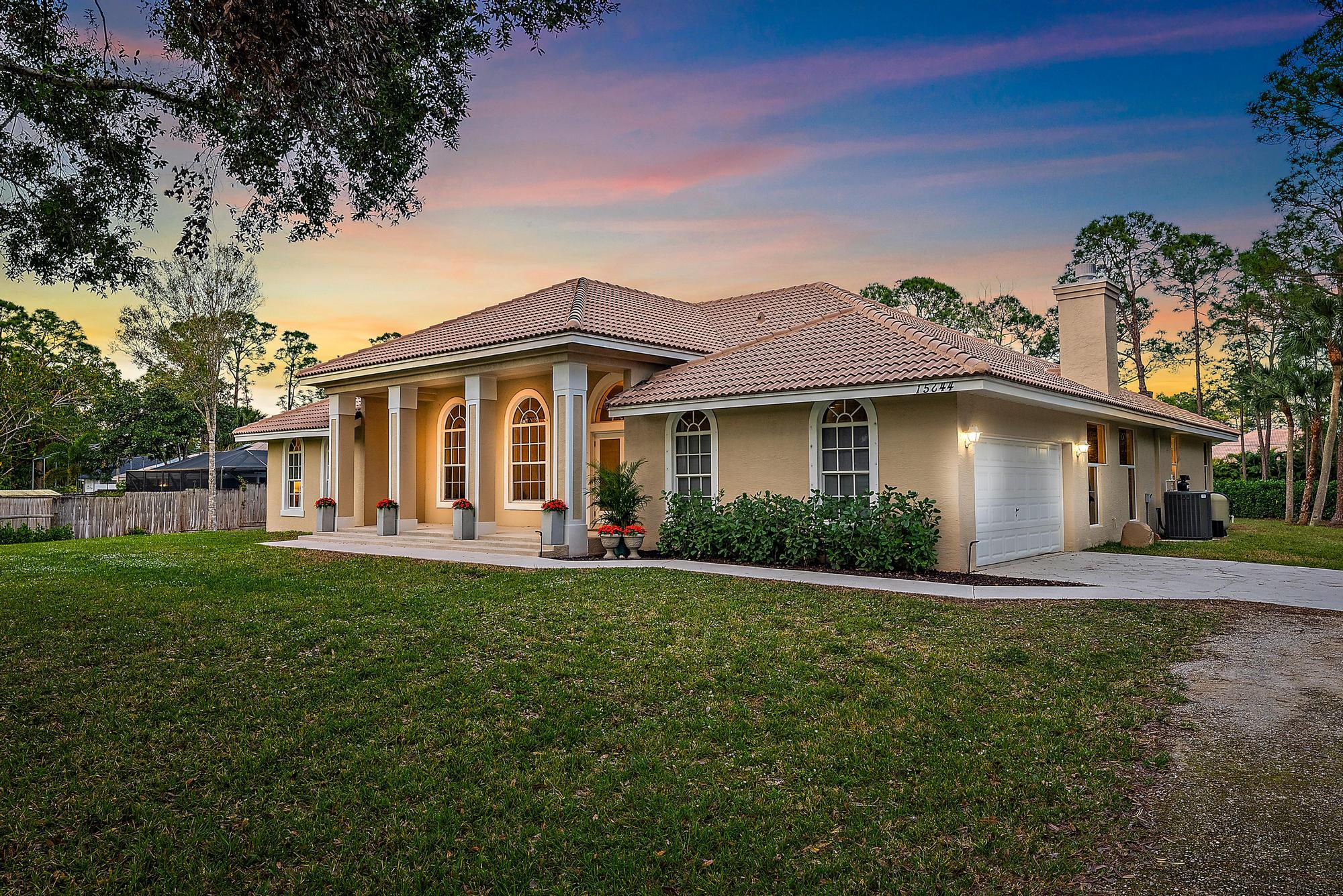 15644 Billy Goat Lane Jupiter, FL 33478 - Photo 32 of 39 a front view of a house with a garden and porch