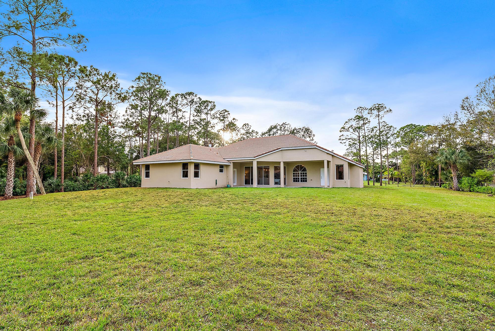 15644 Billy Goat Lane Jupiter, FL 33478 - Photo 34 of 39 a front view of a house with a garden