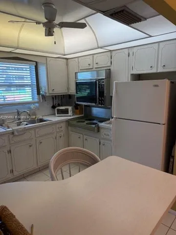 a kitchen with a sink a refrigerator and cabinets