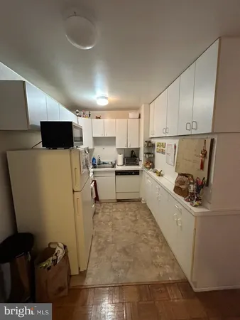a kitchen with a sink a refrigerator and cabinets