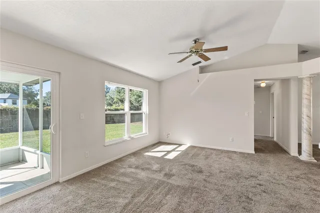 a view of a big room with windows and chandelier fan