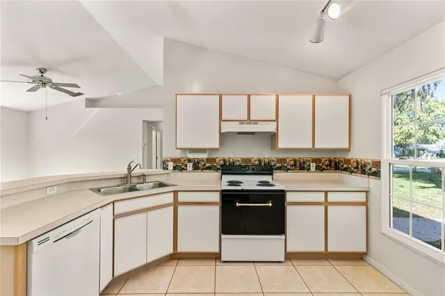 a kitchen with a stove sink and cabinets