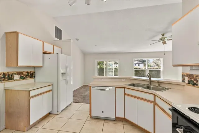 a kitchen with a sink window and cabinets