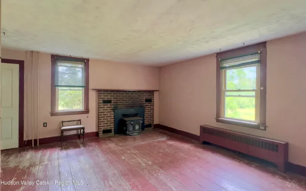 an empty room with windows and fireplace