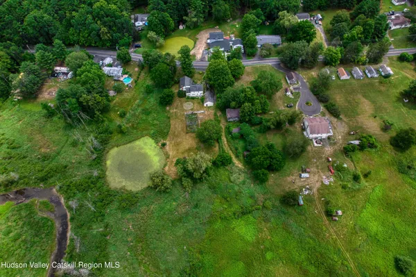 an aerial view of residential house with outdoor space and trees all around