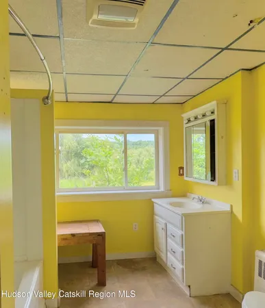 a bathroom with a sink a toilet and next to a window